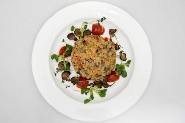 mantar ile pirinç. bir fincan pirinç beyaz tabakta. pirinç ile petrol ve kiraz domates püresi.