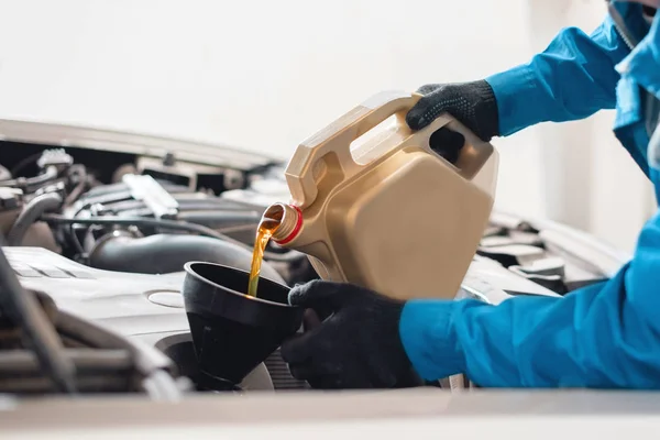Automechaniker gießt neues Motoröl durch einen Trichter — Stockfoto