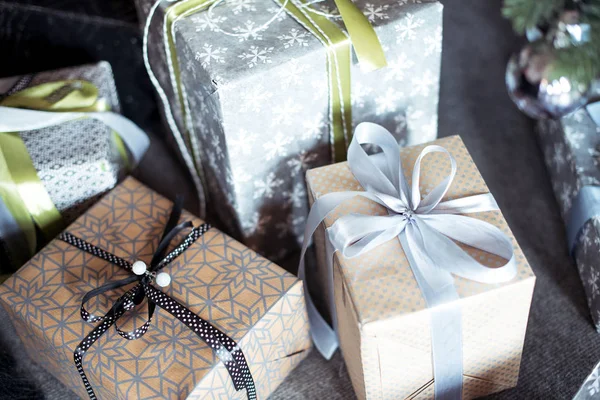 Christmas gifts in decorative boxes wrapped in kraft paper and satin ribbons