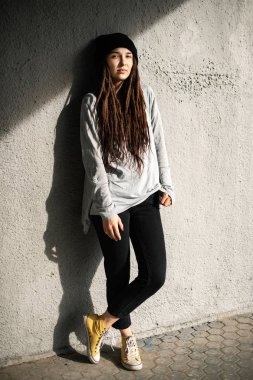 olan dreadlocks beton duvarın yanında siyah şapkalı kız