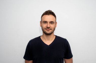 Siyah tişörtlü, sakallı çekici bir adamın portresi. Berber dükkanında yeni bir saç stili olan adam. Kuaförde saç kesimi..