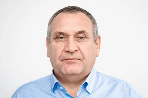 Mavi gömlekli gri saçlı yetişkin bir adamın portresi. emeklilik. Ünlüler Listesi. Adam tıraşlı. Büyükbaba