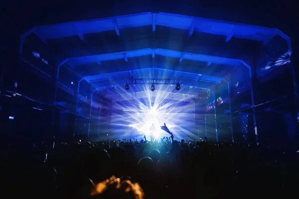 Силуэт Музыканта Сцене Фестиваля Синих Лучах Прожектора Танцующей Толпой Зале — стоковое фото