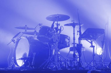 Modern bir rock grubunun davul seti mavi ışıkta sahnede. Konser salonu. müzik festivali posteri