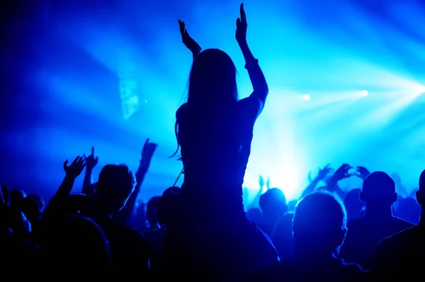 Silhueta de uma menina aplaudindo feliz em uma multidão em um concerto — Fotografia de Stock