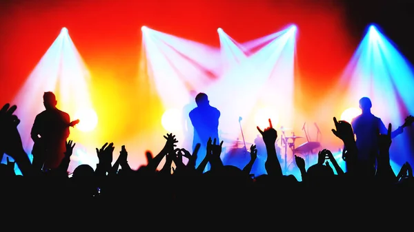 Silhuetas turvas de músicos de banda de rock no palco e multidão em um concerto — Fotografia de Stock