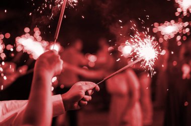 Tatilde neşeli insanların elinde büyük Bengal maytapları. Yeni yıl ya da düğün partisi