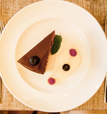 Çikolatalı Pasta krema, nane ve çilek ile dekore edilmiş bir restoranda servis