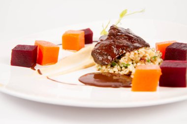 Beyaz zemin üzerine sosu sığır eti yanak sebze, kavrulmuş maydanoz kökü mus, pearl arpa, koyu çikolata ve demi ile şekeri