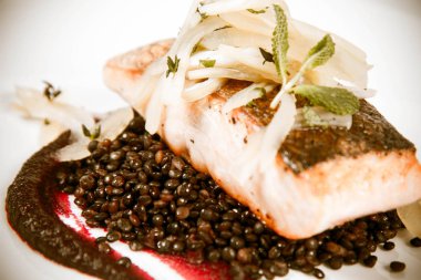 Pişmiş somon, pancar mus, siyah mercimek ve beyaz zemin üzerine armut