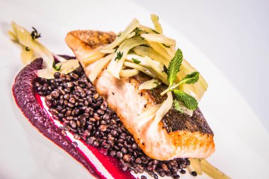 Pişmiş somon, pancar mus, siyah mercimek ve beyaz zemin üzerine armut