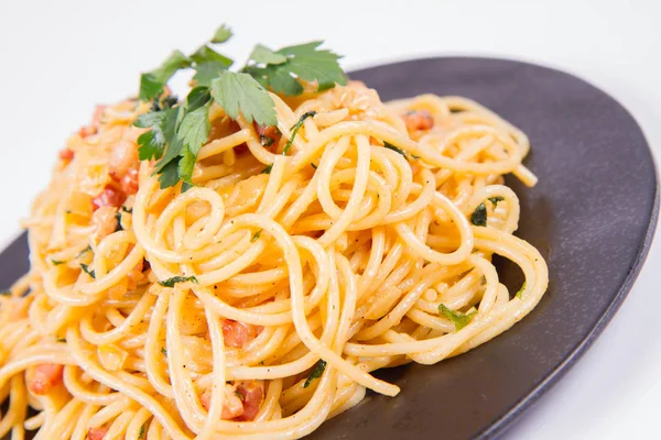 Spagetti Carbonara Beyaz Bir Arka Plan Üzerinde Siyah Bir Plaka — Stok fotoğraf