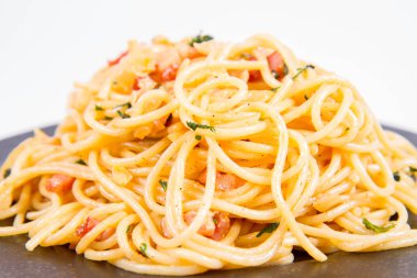 Spagetti Carbonara beyaz bir arka plan üzerinde siyah bir plaka üzerinde bazı maydanoz ile