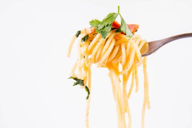 Spagetti Carbonara bazı maydanoz üzerinde beyaz bir arka plan üzerinde bir çatalı ile