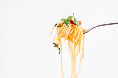 Spagetti Carbonara bazı maydanoz üzerinde beyaz bir arka plan üzerinde bir çatalı ile