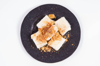 Köfte süzme peynir ile (geleneksel Lehçe çanak denilen tembel pierogi / leniwe pierogi) ekmek kırıntıları ile kızarmış ve şeker ile serpilir