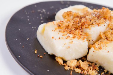 Köfte süzme peynir ile (geleneksel Lehçe çanak denilen tembel pierogi / leniwe pierogi) ekmek kırıntıları ile kızarmış ve şeker ile serpilir