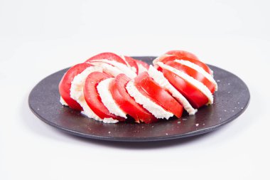 Caprese salatası - mozzarella peyniri ile domates - beyaz bir arka plan üzerinde siyah bir plaka üzerinde