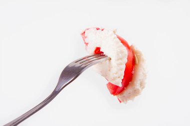 Caprese salatası - beyaz bir arka plan üzerinde bir çatalı üzerinde mozzarella peyniri ile domates