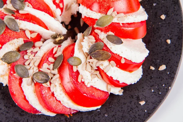 Caprese Salad Tomato Mozzarella Sunflower Pumpkin Seeds Black Plate White — Stock Photo, Image