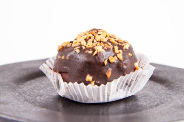 Çikolata ve fındık beyaz bir arka plan üzerinde siyah bir tabakta romlu süslenmiş