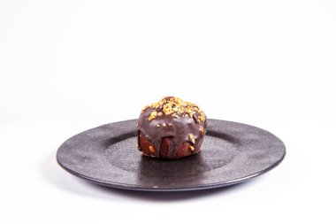 Çikolata ve fındık beyaz bir arka plan üzerinde siyah bir tabakta romlu süslenmiş