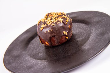Çikolata ve fındık beyaz bir arka plan üzerinde siyah bir tabakta romlu süslenmiş