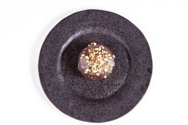 Çikolata ve fındık beyaz bir arka plan üzerinde siyah bir tabakta romlu süslenmiş