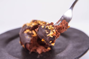 Çikolata ve fındık beyaz zemin üzerinde bir çatal ile yenen siyah plaka ile dekore edilmiş romlu
