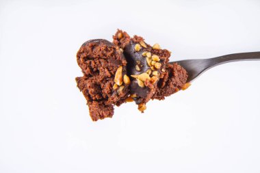 Çikolata ve fındık üzerinde beyaz bir arka plan üzerinde bir çatalı romlu süslenmiş