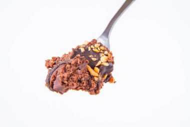 Çikolata ve fındık üzerinde beyaz bir arka plan üzerinde bir çatalı romlu süslenmiş