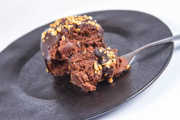 Ρούμι Σφαιρών Διακοσμημένα Σοκολάτα Και Ξηρούς Καρπούς Ένα Μαύρο Πιάτο — Φωτογραφία Αρχείου