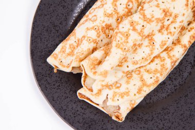 Siyah bir tabak kızarmış elma krep dolması