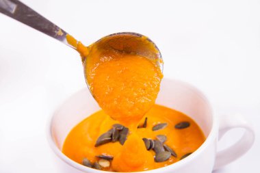 Kabak çekirdeği bir kaseye bir ahşap arka plan üzerine dökülür varlık ile dekore edilmiş balkabağı çorbası