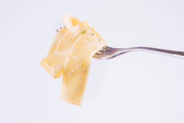Pappardelle Carbonara üzerinde beyaz bir arka plan üzerinde bir çatalı