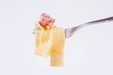 Pappardelle Carbonara üzerinde beyaz bir arka plan üzerinde bir çatalı