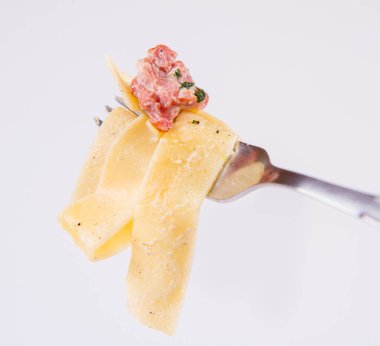Pappardelle Carbonara üzerinde beyaz bir arka plan üzerinde bir çatalı
