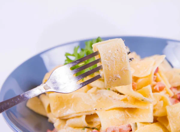 Pappardelle Carbonara Çatalla Yenir Beyaz Zemin Üzerinde Mavi Bir Plaka — Stok fotoğraf