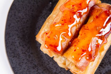 Siyah bir plaka üzerinde Çince Geleneksel bahar rulo tatlı ve ekşi sos ile