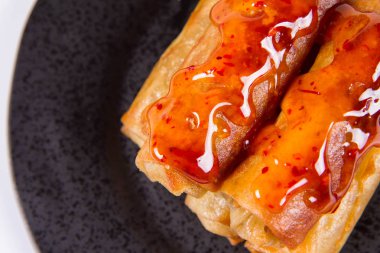 Siyah bir plaka üzerinde Çince Geleneksel bahar rulo tatlı ve ekşi sos ile