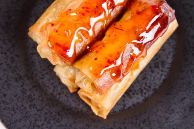 Siyah bir plaka üzerinde Çince Geleneksel bahar rulo tatlı ve ekşi sos ile