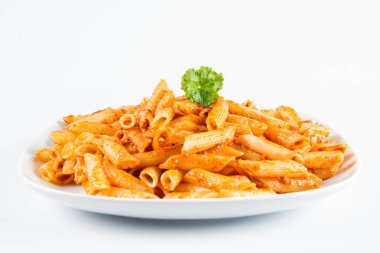 Beyaz zemin üzerinde bir tabakta maydanoz penne pesto ile süslenmiş