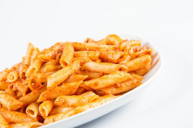 Penne pesto beyaz zemin üzerinde bir tabakta ile
