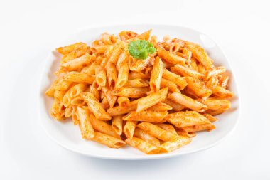 Beyaz zemin üzerinde bir tabakta maydanoz penne pesto ile süslenmiş