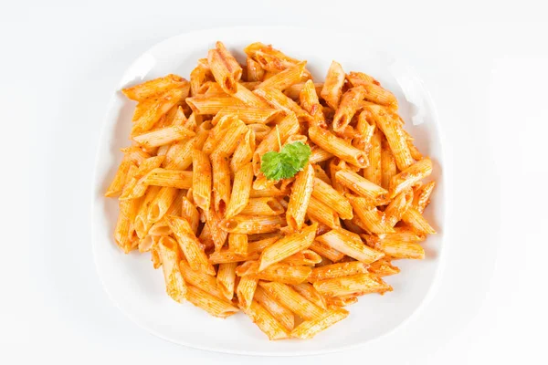 Beyaz zemin üzerinde bir tabakta maydanoz penne pesto ile süslenmiş