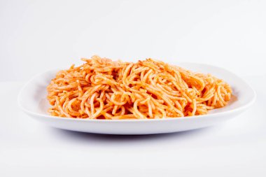 Beyaz zemin üzerinde bir tabakta pesto ile spagetti