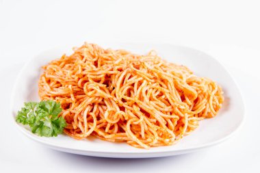 Beyaz zemin üzerinde bir tabakta maydanoz spagetti pesto ile süslenmiş