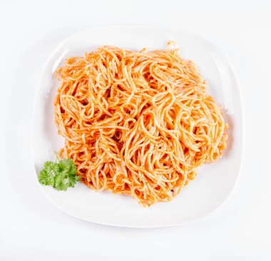 Beyaz zemin üzerinde bir tabakta maydanoz spagetti pesto ile süslenmiş
