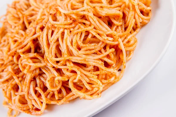 白い背景の上のプレートにバジルソースのスパゲッティ — ストック写真