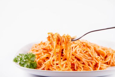 Beyaz zemin üzerinde bir çatal ile yemiş maydanoz spagetti pesto rosso ile süslenmiş